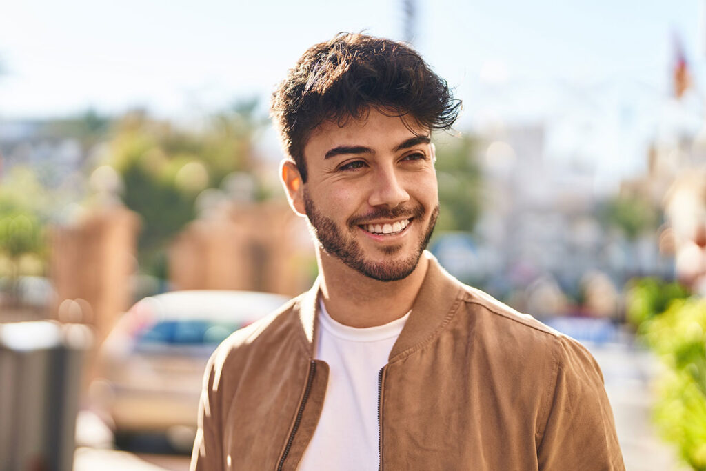 Young man smiling outside