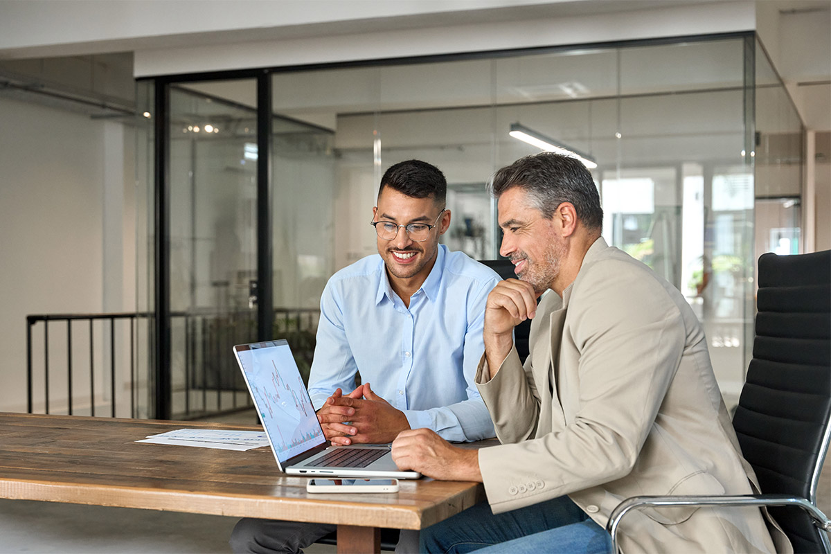 Two male business workers view DMB merchant services online